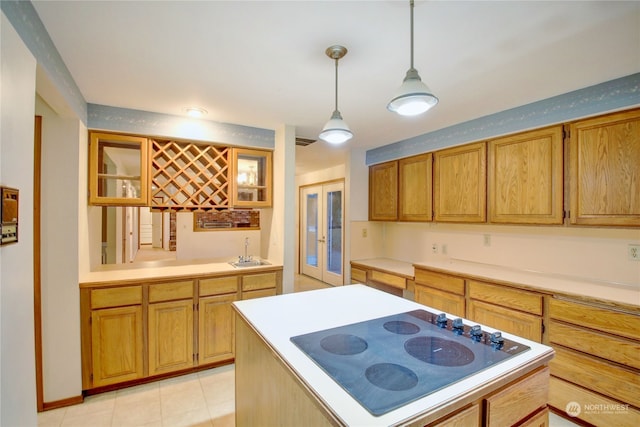 kitchen with pendant lighting, sink, electric stovetop, light tile patterned floors, and french doors