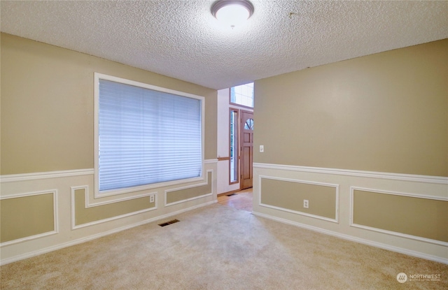 carpeted empty room with a textured ceiling