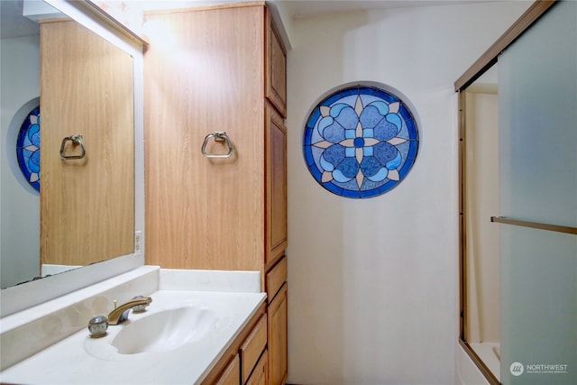 bathroom with vanity and a shower with shower door