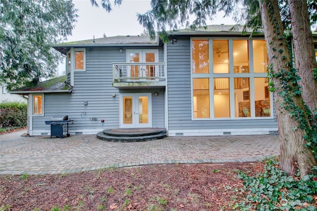 back of house featuring french doors, a balcony, and a patio