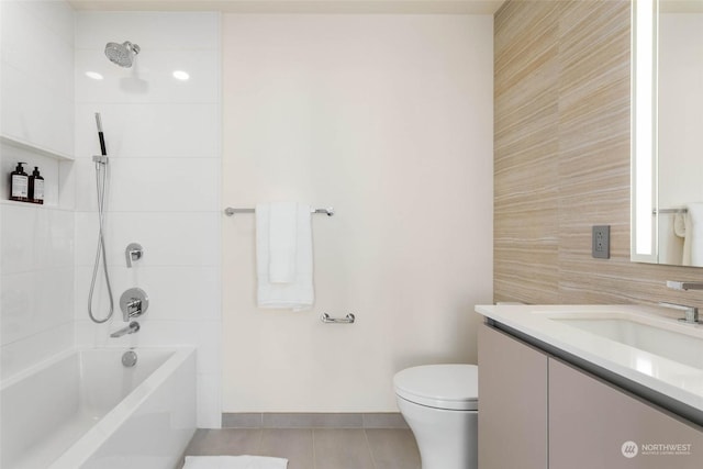 full bathroom with tile patterned flooring, vanity, tiled shower / bath combo, and toilet