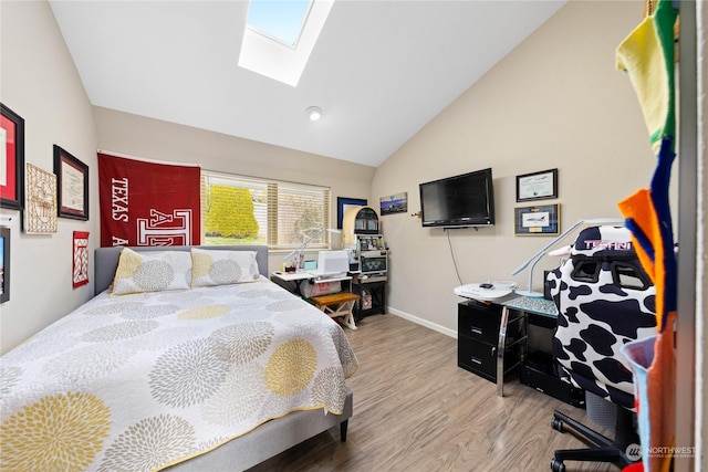 bedroom with hardwood / wood-style flooring and vaulted ceiling with skylight