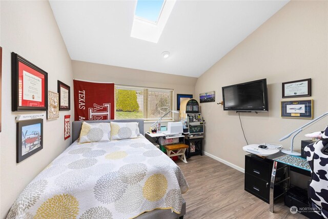 bedroom with hardwood / wood-style flooring and vaulted ceiling with skylight