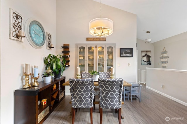 dining area featuring dark wood-type flooring and high vaulted ceiling