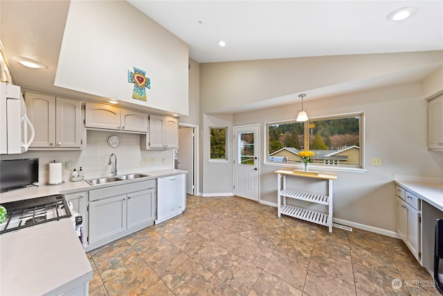 kitchen featuring vaulted ceiling, white appliances, sink, and hanging light fixtures