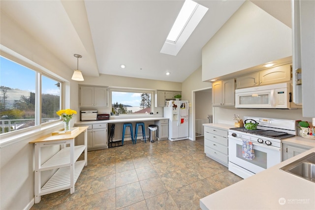 kitchen featuring pendant lighting, white appliances, a skylight, and a healthy amount of sunlight