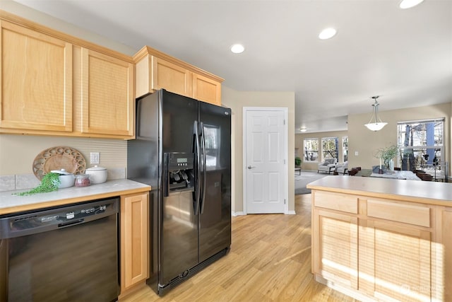 kitchen featuring light hardwood / wood-style floors, pendant lighting, light brown cabinetry, and black appliances