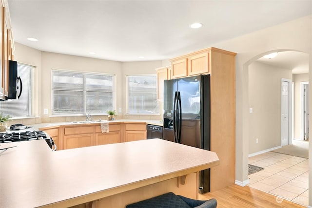 kitchen featuring light hardwood / wood-style flooring, sink, light brown cabinets, and black appliances