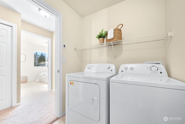 laundry room with washing machine and dryer and light carpet