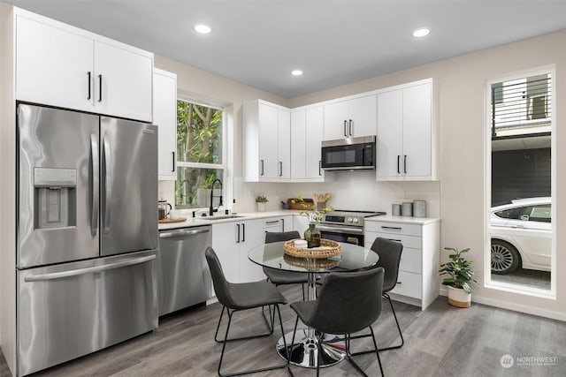 kitchen featuring tasteful backsplash, stainless steel appliances, sink, and white cabinets