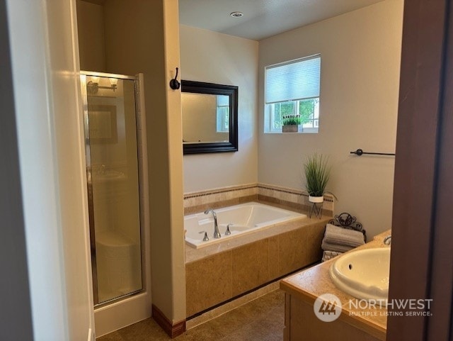 bathroom with vanity and shower with separate bathtub