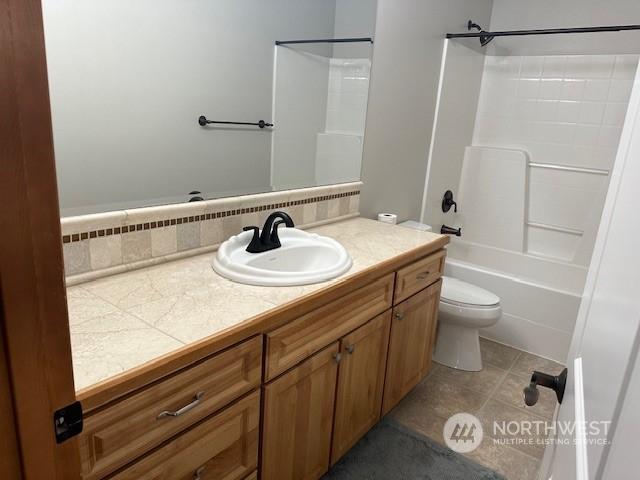 full bathroom featuring vanity, tile patterned flooring, shower / washtub combination, and toilet