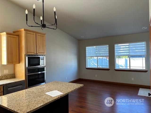 kitchen featuring built in microwave, light stone countertops, black dishwasher, and oven