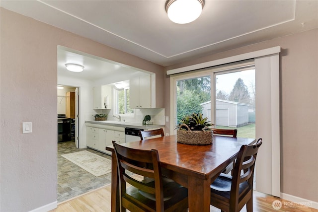 dining room with sink and light wood-type flooring