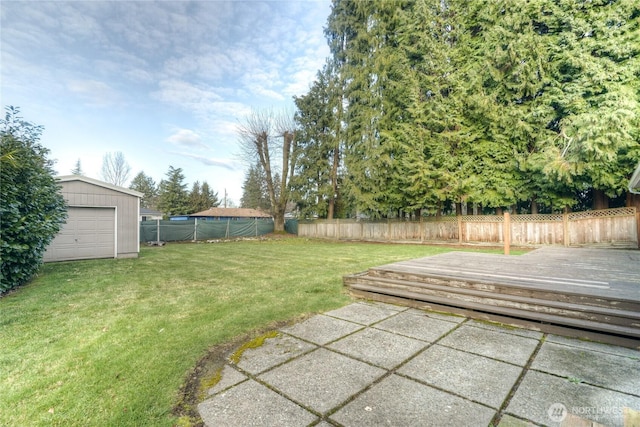 view of yard with a garage, a wooden deck, and an outdoor structure