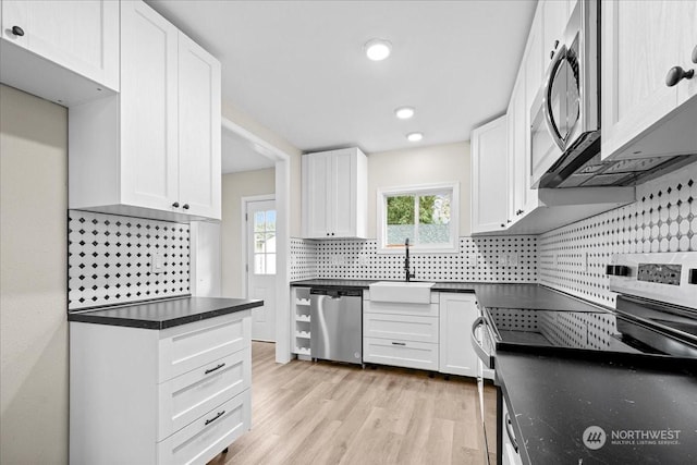 kitchen with sink, backsplash, stainless steel appliances, light hardwood / wood-style floors, and white cabinets