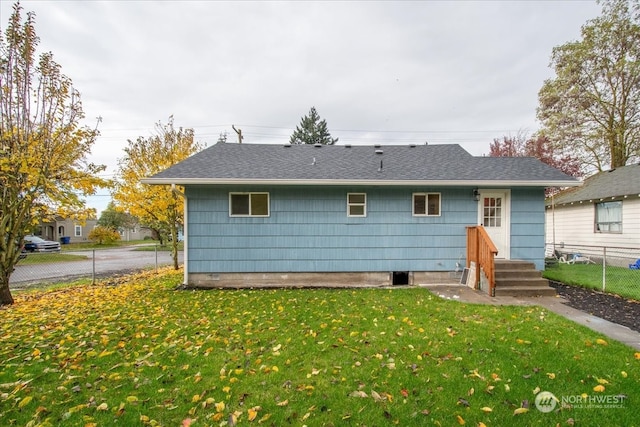 rear view of house featuring a yard