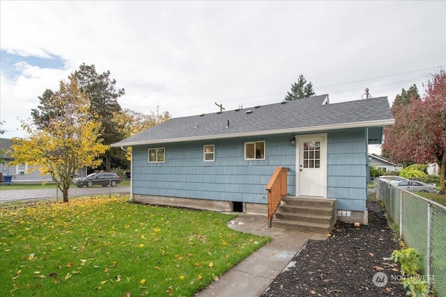 rear view of house featuring a yard