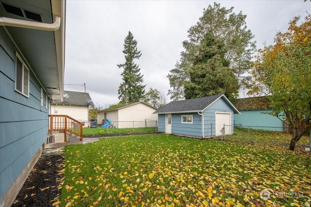 view of yard featuring a garage and an outbuilding