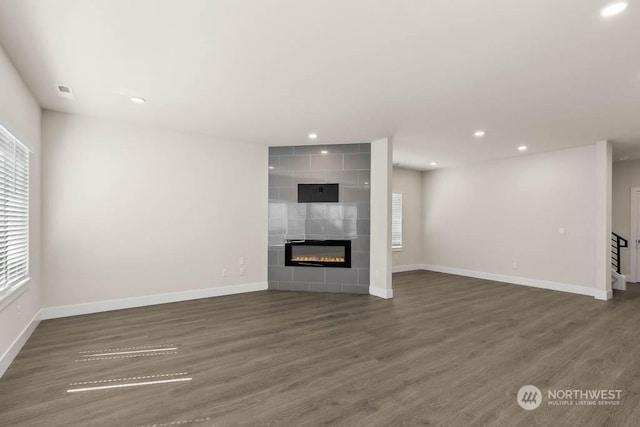 unfurnished living room featuring dark hardwood / wood-style flooring and a fireplace