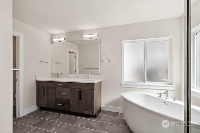 bathroom with vanity, tile patterned flooring, and a bathtub