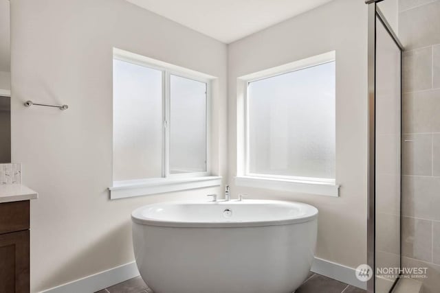 bathroom with tile patterned flooring, vanity, and a tub