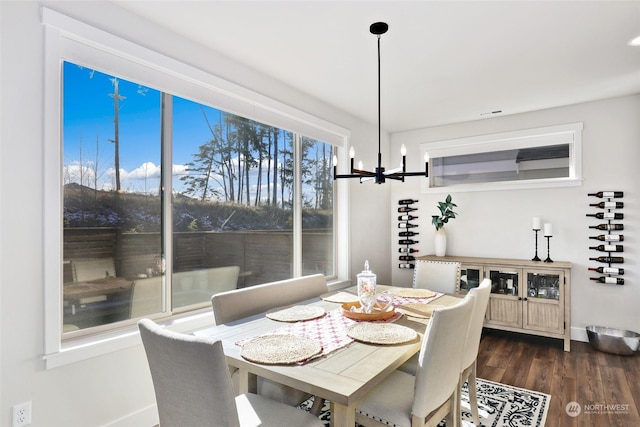 dining area featuring a notable chandelier and dark wood-type flooring