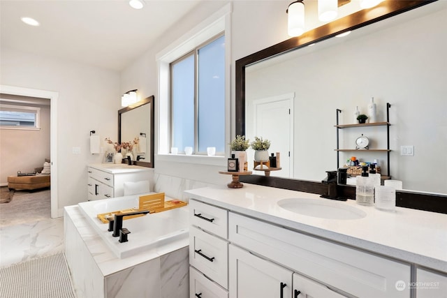 bathroom featuring vanity, a healthy amount of sunlight, and tiled bath