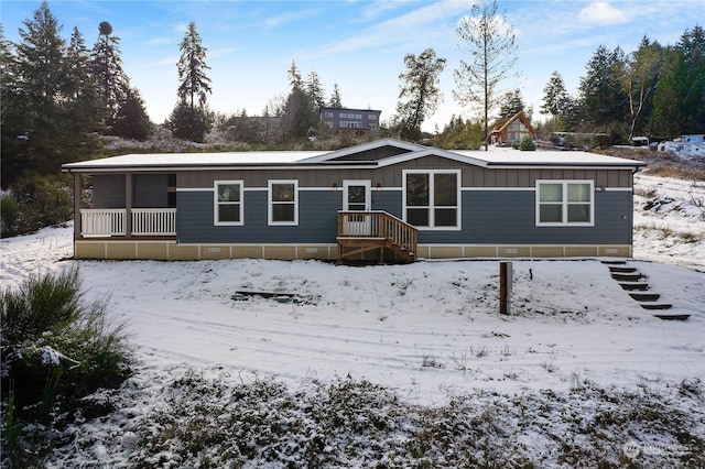 view of snow covered back of property