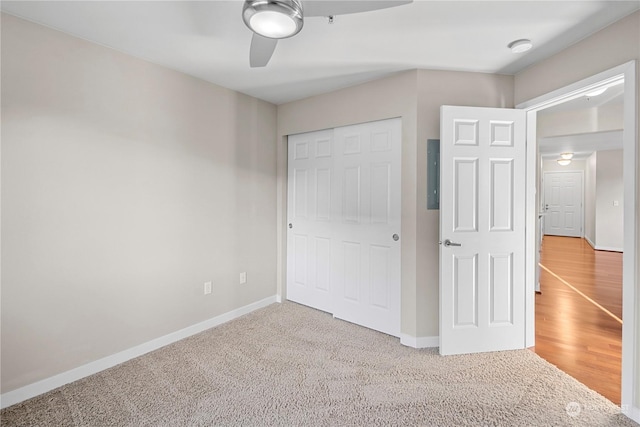 unfurnished bedroom with electric panel, a closet, ceiling fan, and carpet flooring