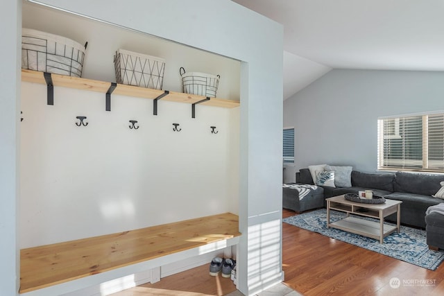 mudroom featuring wood-type flooring and vaulted ceiling