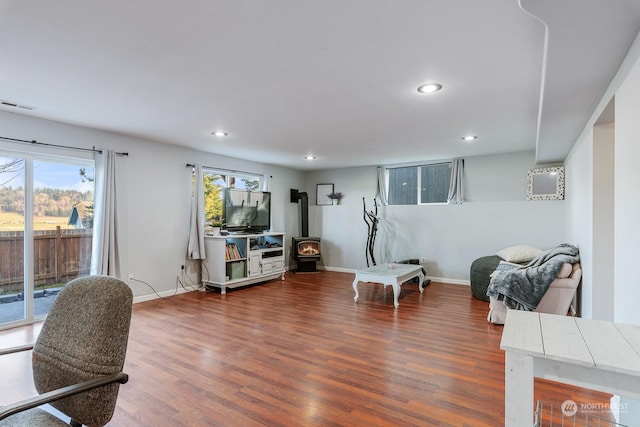 interior space featuring a healthy amount of sunlight, dark wood-type flooring, and a wood stove