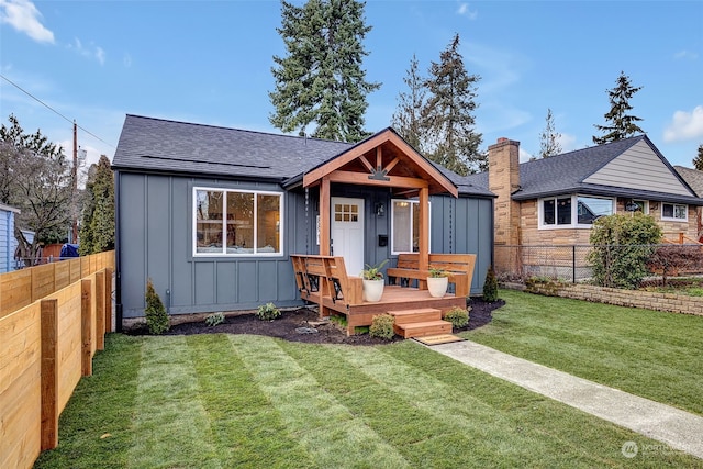 view of front of house with a deck and a front yard