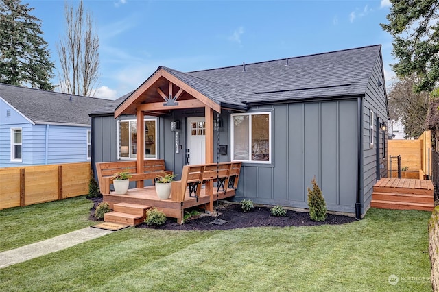 view of front facade with a wooden deck and a front yard