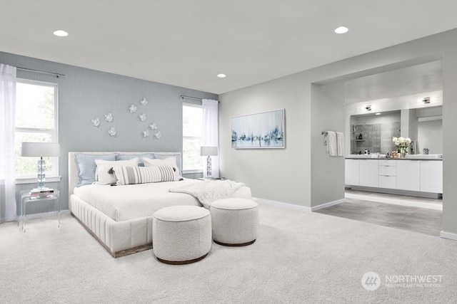 carpeted bedroom featuring multiple windows and ensuite bathroom