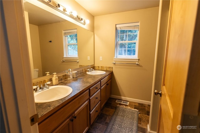 bathroom with vanity, a healthy amount of sunlight, and toilet