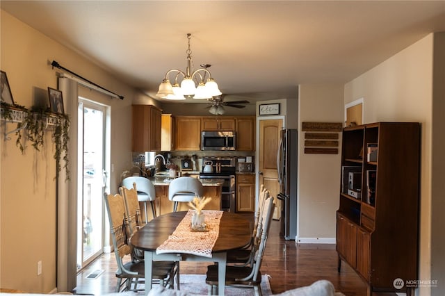 dining room with dark hardwood / wood-style flooring, sink, and ceiling fan with notable chandelier