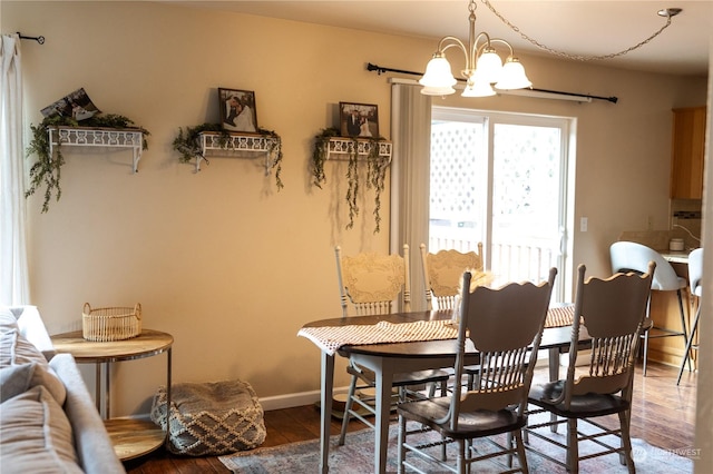 dining area with hardwood / wood-style flooring and an inviting chandelier