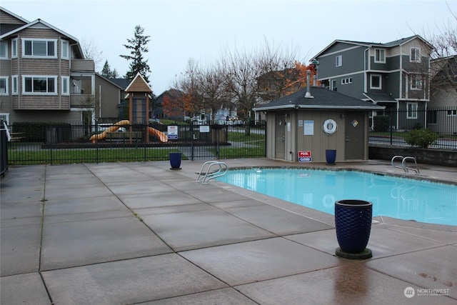 view of pool with a playground and a patio area