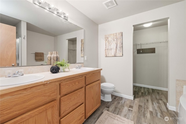 bathroom with hardwood / wood-style flooring, vanity, and toilet