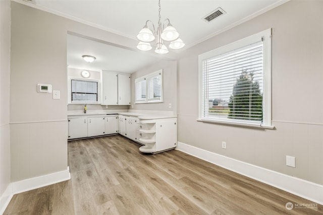 interior space with sink, white cabinetry, a chandelier, hanging light fixtures, and light hardwood / wood-style flooring