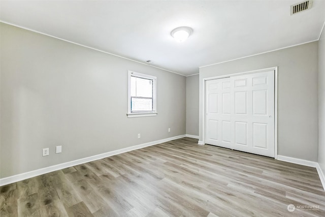 unfurnished bedroom with light hardwood / wood-style floors and a closet