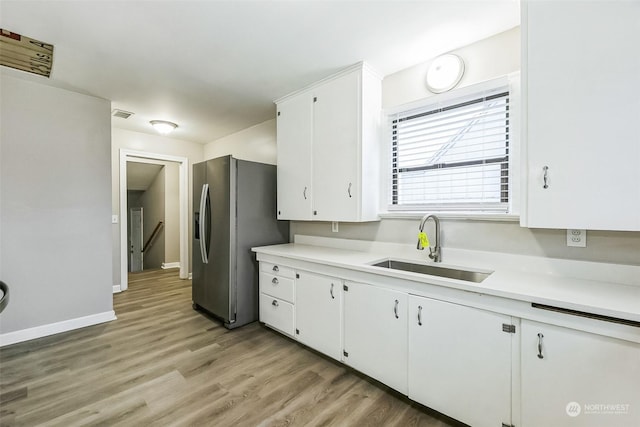 kitchen featuring white cabinetry, sink, light wood-type flooring, and stainless steel refrigerator with ice dispenser