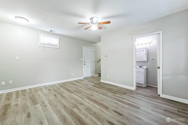 unfurnished bedroom featuring ensuite bathroom, ceiling fan, and light wood-type flooring