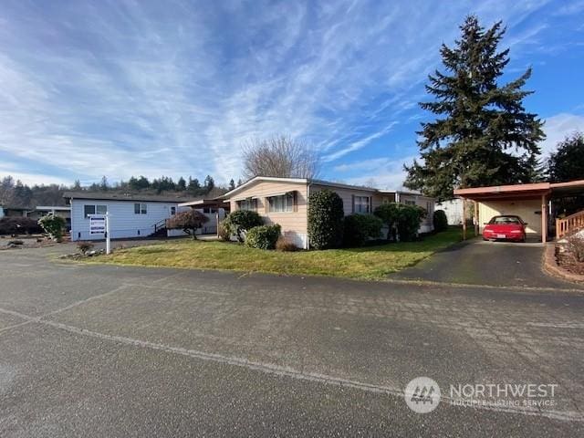 single story home featuring a front lawn and a carport