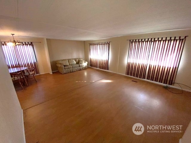 unfurnished living room with hardwood / wood-style floors and a chandelier