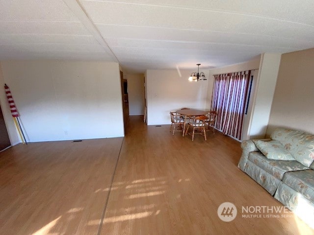 unfurnished living room with hardwood / wood-style flooring and a chandelier