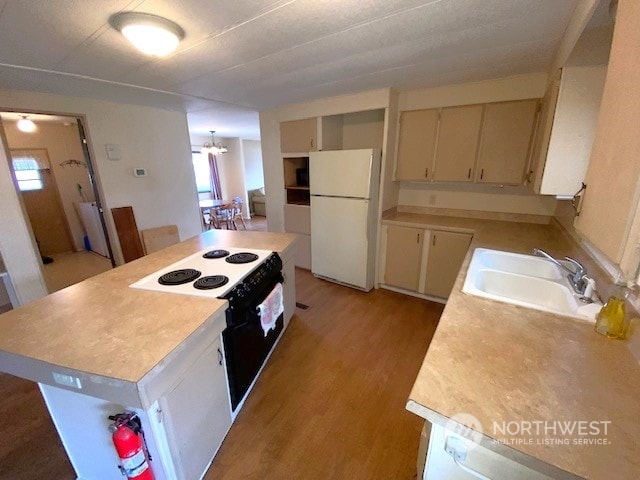 kitchen with sink, white refrigerator, a notable chandelier, electric range, and light wood-type flooring