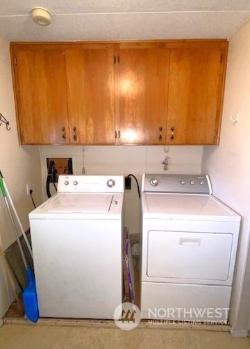 laundry room featuring cabinets and washer and clothes dryer