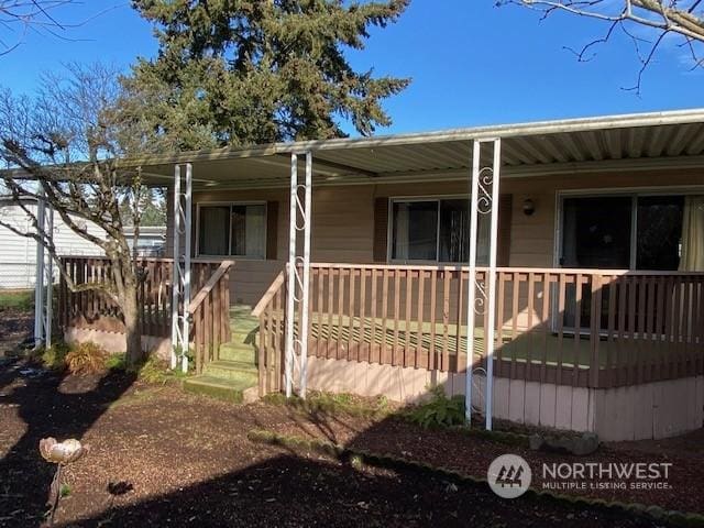 rear view of property featuring covered porch